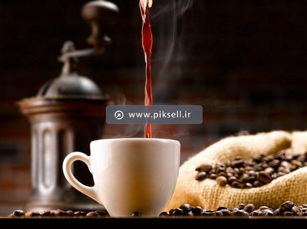 تصویر با کیفیت از قهوه داغ در فنجان و دانه های قهوه