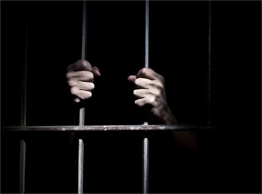دانلود تصویر با کیفیت از مردی پشت میله های زندان و پس زمینه سیاه